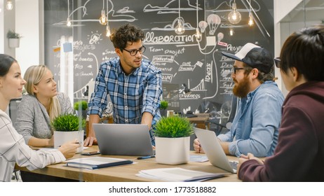 Creative Project Manager Talks to Talented Young Developers at the Team Meeting, They Discuss, Aims, Goals and New Year Plans. Stylish Business Office.
