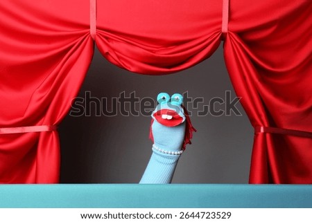 Creative puppet show on stage with red curtains