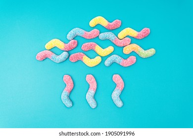 Creative Raining Cloud Flat Lay Made Of Colored Sugar Coated Gummy Worms On A Light Blue Background