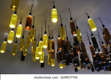 Creative reuse of wine bottles as lamps installed on the ceiling - Shutterstock ID 1039077796