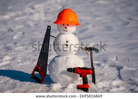 Creative snowman worker with construction tools and hardhat. Cute snow man builder. Snowman engineer holds hammer and measures. Snowman handyman using tools.