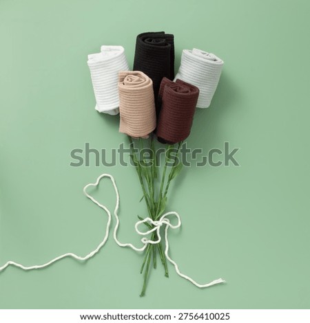 Creative sock design: a spring bouquet of twisted socks on a green background. Top view. Flat lay. 
