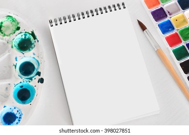 Creative space mock up: an album for watercolors, wood structure, palette and brush. - Shutterstock ID 398027851