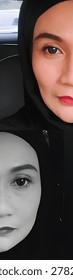 Creative split-screen vertical collage showing two halves of a beautiful Southeast Asian Muslim woman's face. 
The top image displays a close-up portrait in vibrant color with bold red lipstick, defined eyebrows, and grey contact lenses. 
The bottom image is a mirrored black and white portrait, creating a dramatic, artistic, and symmetrical duality concept. Perfect for beauty, makeup, hijab fashion, and conceptual art themes.