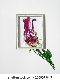 Creative spring concept made. Bouquet of flowers as paint brush and colorful roses on white background. Minimal nature flat lay in gray frame.
