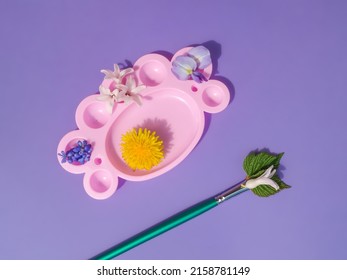 Creative spring layout made violets  dandelion   hyacinth flowers pink paint palette   painting brush against gradient purple background  Natural minimal concept  Creative spring idea 