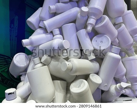 Creative stack of plain white plastic bottles and cosmetic containers, representing recycling, sustainable packaging, plastic waste reduction and eco friendly environmental awareness concept.
