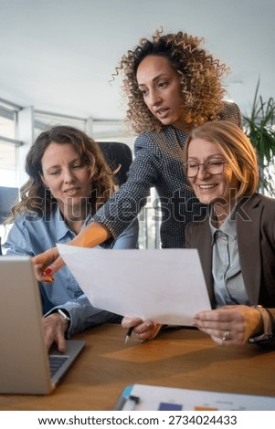Creative startup team collaborating with AI software on laptop in modern workplace, innovation, teamwork, and digital technology concept