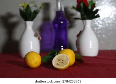 A creative still-life composition featuring white vases with flowers, eggs and fresh citrus fruits on a red surface with copy space.