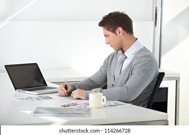 Creative student working with his laptop at desk