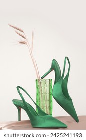 Creative studio shot of green satin slingbacks heels with the classy pointed toe, product photography	