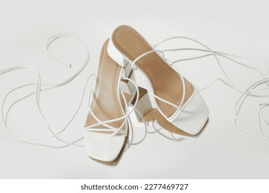 Creative studio shot of white strappy lace up block heel sandals, product photography - Shutterstock ID 2277469727