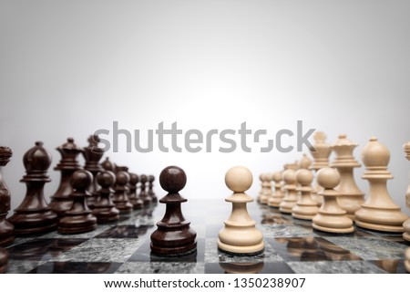 Creative success business concept meaningful photo of two pawns opposition in the middle of the checkerboard.