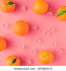 Creative summer pattern made of oranges and ice cubes on vivid pink background. Fruit minimal concept.