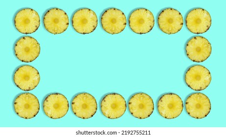Creative summer pattern made of pineapple rings against pastel blue background. Original pineapple decoration. Creative summer idea. Fruit art. Copy space. Pineapple frame.
