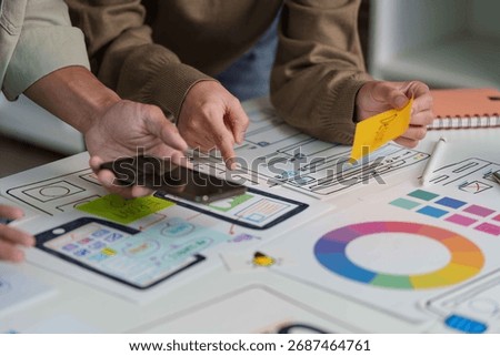 Creative Team Engaging in UX Design with Prototypes and Color Schemes