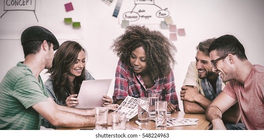 Creative Team Going Over Contact Sheets In Meeting In Office With Whiteboard