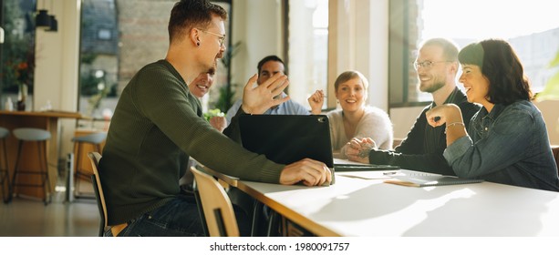 Creative team having meeting for sharing new ideas. Men and women discussing startup business. - Shutterstock ID 1980091757