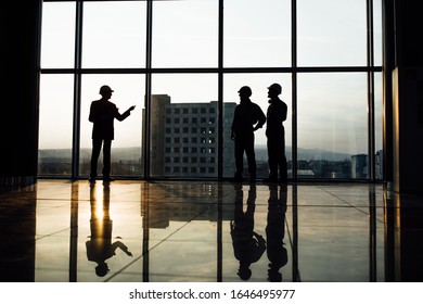 Creative teem engineers looking at the panorama window, back view photo.
