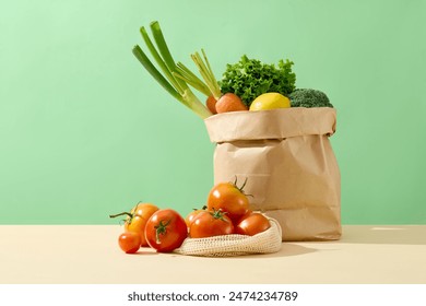 Creative template for designing with frontal shot against green color background, some ripe tomatoes flat lay on yellow countertop, next to a paper bag of vegetable. Empty space for text - Powered by Shutterstock