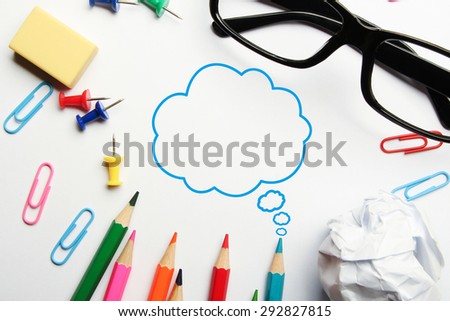 Creative thinking bubble concept with some office supplies around it on white background.