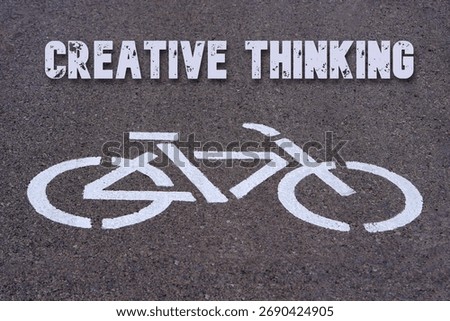 creative thinking concept. words written on the asphalt above the symbol of a bicycle