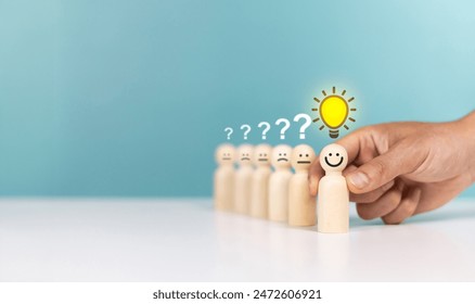 Creative, creative thinking ,idea, problem solving, innovation. Hand hold wooden figurines with glowing lightbulb in front of sad figurines with questionmark - Powered by Shutterstock