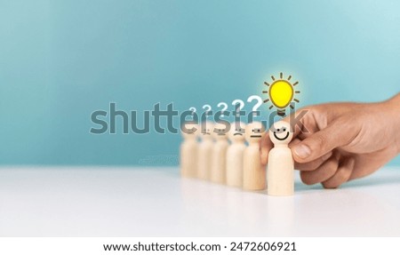 Creative, creative thinking ,idea, problem solving, innovation. Hand hold wooden figurines with glowing lightbulb in front of sad figurines with questionmark