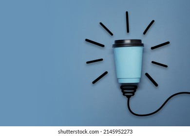 Creative Thinking Ideas And Innovation Concept. A Ball Of Takeaway Coffee Cup With A Light Bulb Symbol On A Blue Background. Time For Coffee.