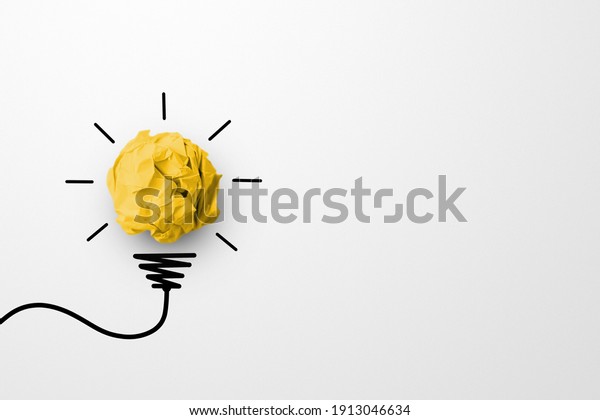 Creative thinking ideas and innovation\
concept. Paper scrap ball yellow colour with light bulb symbol on\
white background