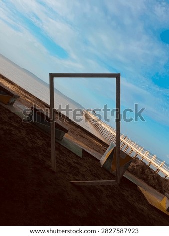Creative Tilted Beach Scene with Framed View of Wooden Pier and Blue Sky