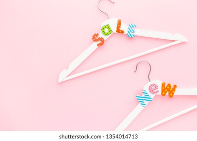 Creative top view flat lay white wooden hangers sale text pastel pink background copy space minimalism style. Template fashion feminine social media sale children store promo design shopping concept - Shutterstock ID 1354014713