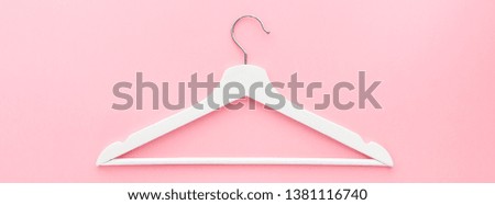 Creative top view flat lay white wooden hangers pastel millennial pink background with copy space minimalism style. Template fashion feminine blog social media sale store promo design shopping concept