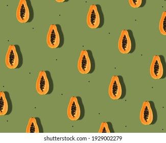 Creative tropical  pattern with orange papaya fruit  and  seeds over  green background. Summes abstract minimal background.