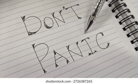 Creative Typography of DON'T PANIC in Notebook with Arrow Embellishments and Diagonal Pen Placement