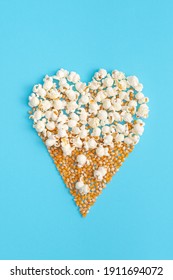 Creative Valentines day concept with heart shape made of popcorn on pastel blue background. Flat lay design.