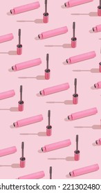Creative vertical crop pattern with mascara brush on sunny pink background. Cosmetic studio concept