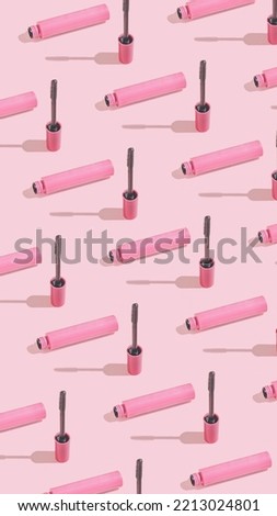 Creative vertical crop pattern with mascara brush on sunny pink background. Cosmetic studio concept