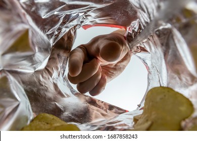 Creative View From Inside A Bag Of Potato Chips With A Hand Reaching For A Chip