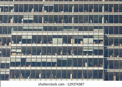 A creative view of rows of windows on the sides of two modern office buildings.