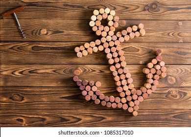 Creative Wine Cork Still Life In The Shape Of A Ships Anchor On A Rustic Wood Background With Corkscrew Or Opener