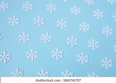 Creative winter pattern made with snowflakes on pastel blue background. Minimal Christmas or New year concept. Flat lay, top view.