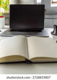 Creative work desk scene with open journal and laptop, clean aesthetic, planning and focus concept in a bright home office.