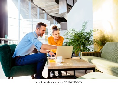 Creative Worker Showing Project To Client On Laptop During Meeting In Cafe