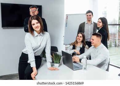 Creative workers  funning and smiling in modern office sitting with laptop and discussing something..