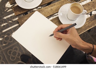 Creative working process. Close-up top view of male hands holding a pen. 