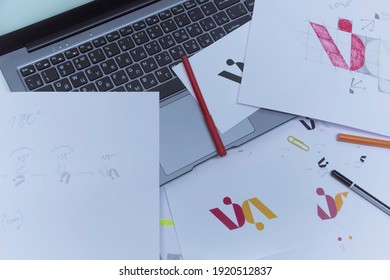 Creative Workplace Of A Graphic Designer. Development Of A Logo For The Company. Drawings And Sketches On Paper In A Art Studio Office