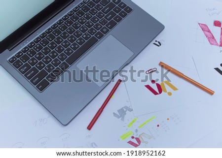 Creative workplace of a Graphic Designer. Development of a logo for the company. Drawings and sketches on paper in a art studio office