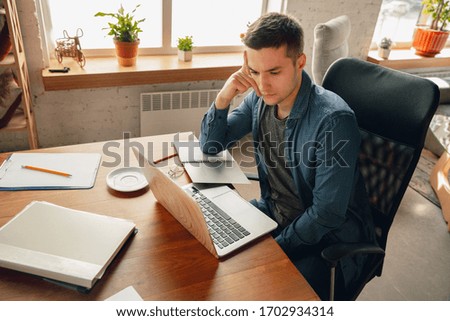 Creative workplace - organized work space as you like for inspiration. Man working in office in comfortable attire, relaxed position and messy table. Choose atmosphere you want - ideal clear or chaos.