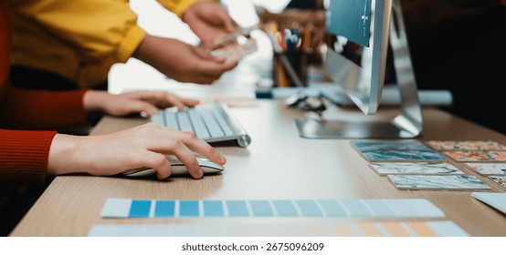 A creative workspace featuring a person using a computer mouse while color palettes and design materials are arranged neatly on the desk, showcasing a vibrant workspace. SACTR - Powered by Shutterstock - Get 15% off with code: PIKWIZARD15